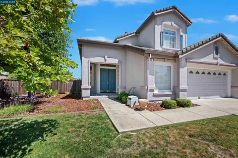 a front view of a house with a yard outdoor seating and garage
