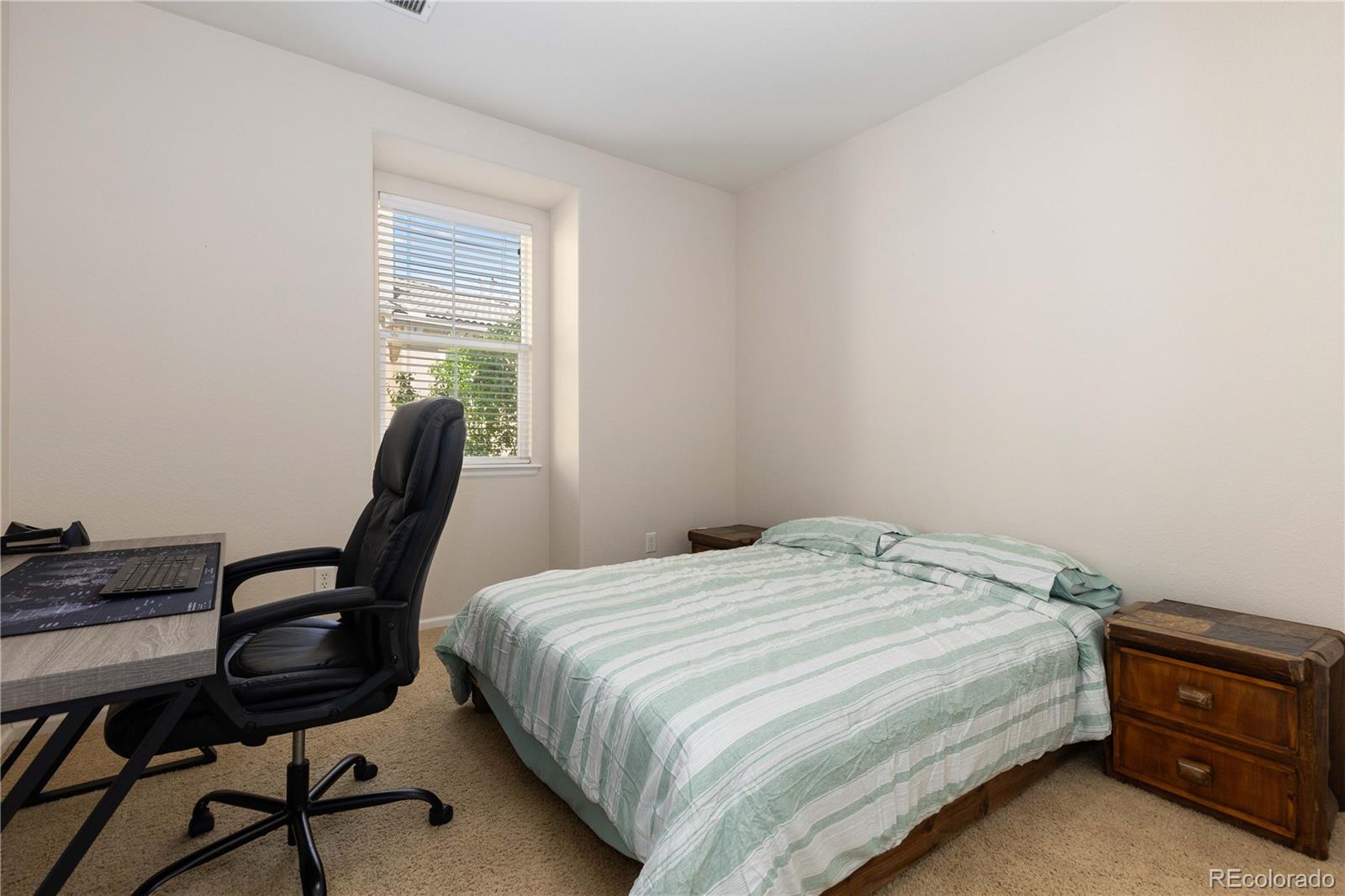 3454 Cascina Place, Unit D Highlands Ranch, CO 80126 - Photo 11 of 31 a bedroom with a bed a desk and chair with wooden floor
