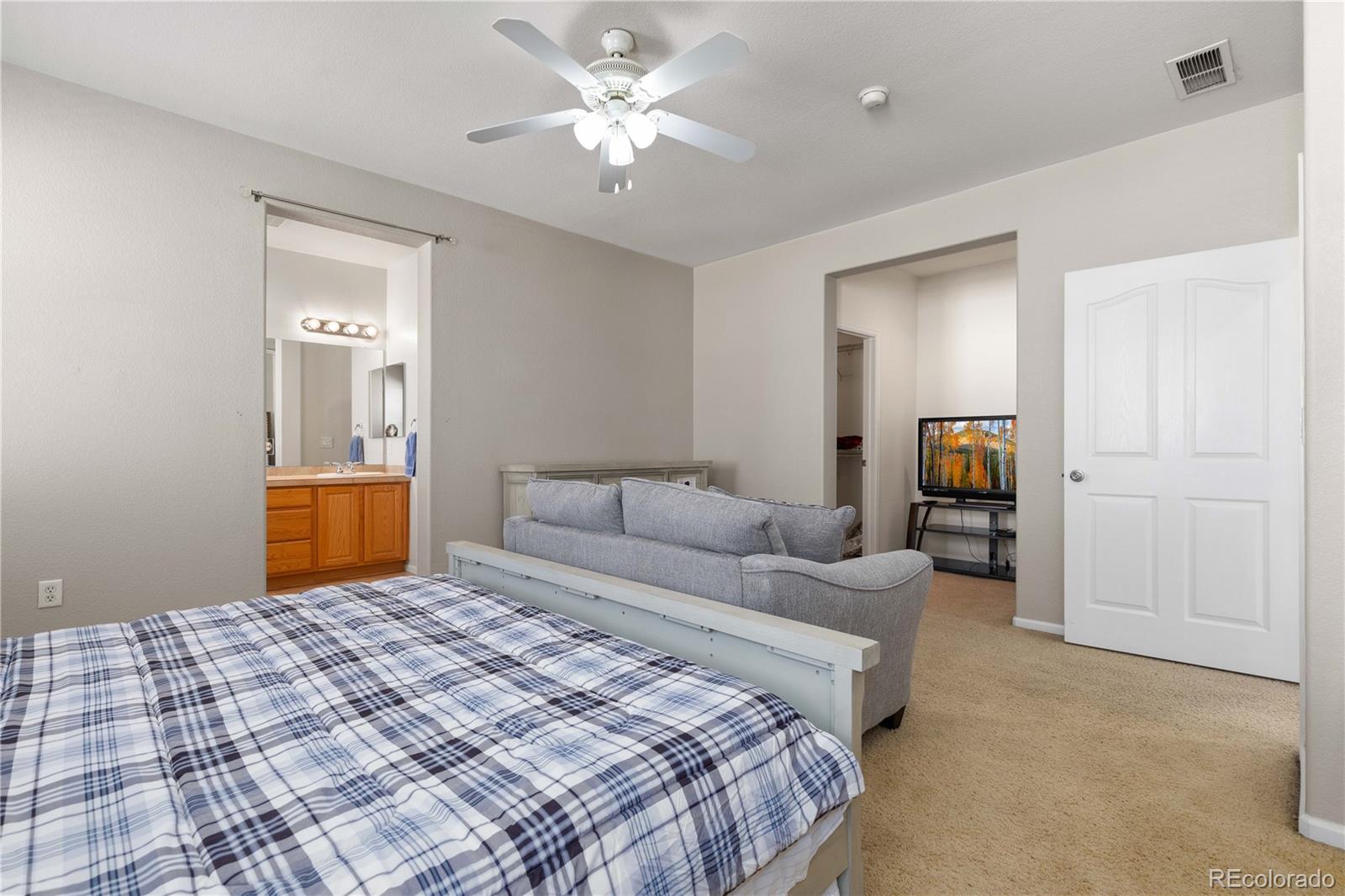 3454 Cascina Place, Unit D Highlands Ranch, CO 80126 - Photo 18 of 31 a bedroom with a large bed and a chandelier