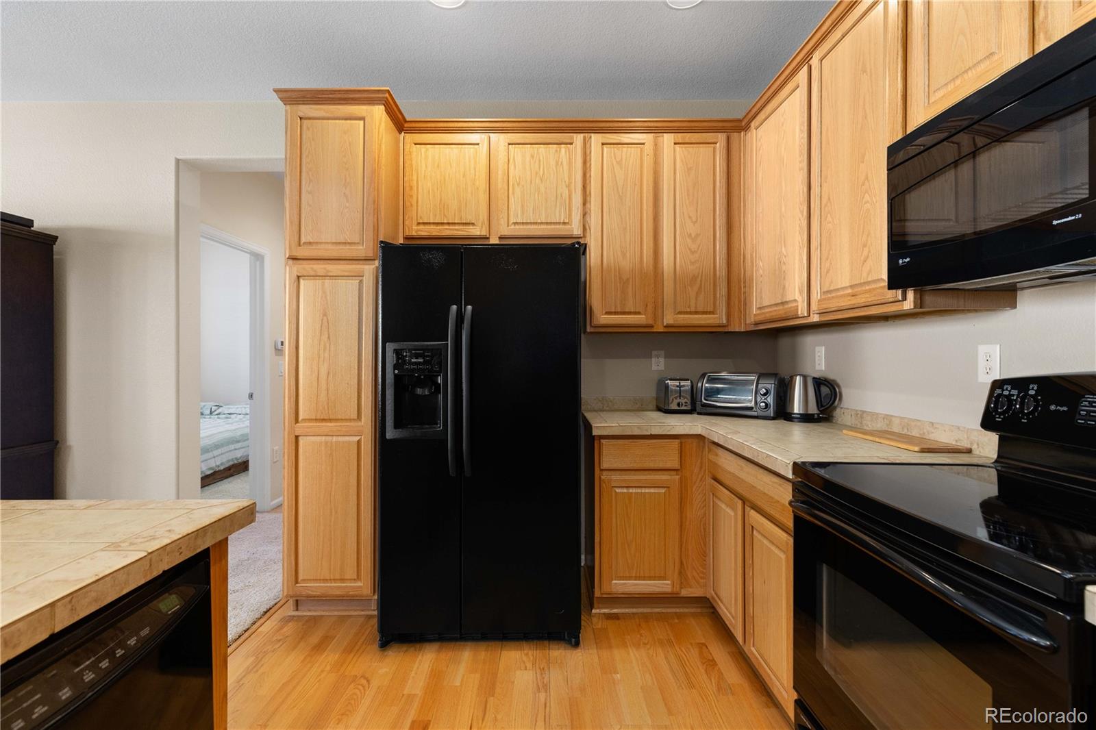 3454 Cascina Place, Unit D Highlands Ranch, CO 80126 - Photo 10 of 31 a kitchen with a refrigerator and a stove top oven