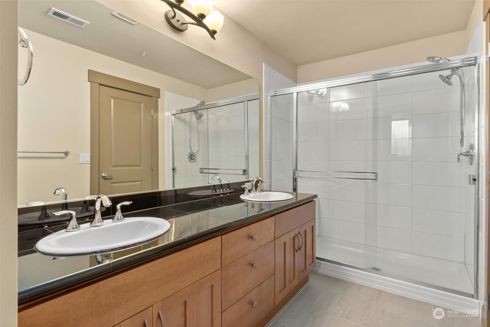2115 201st Place Southeast, Unit I4 Bothell, WA 98012 - Photo 17 of 24 a bathroom with a granite countertop sink a mirror a and a shower