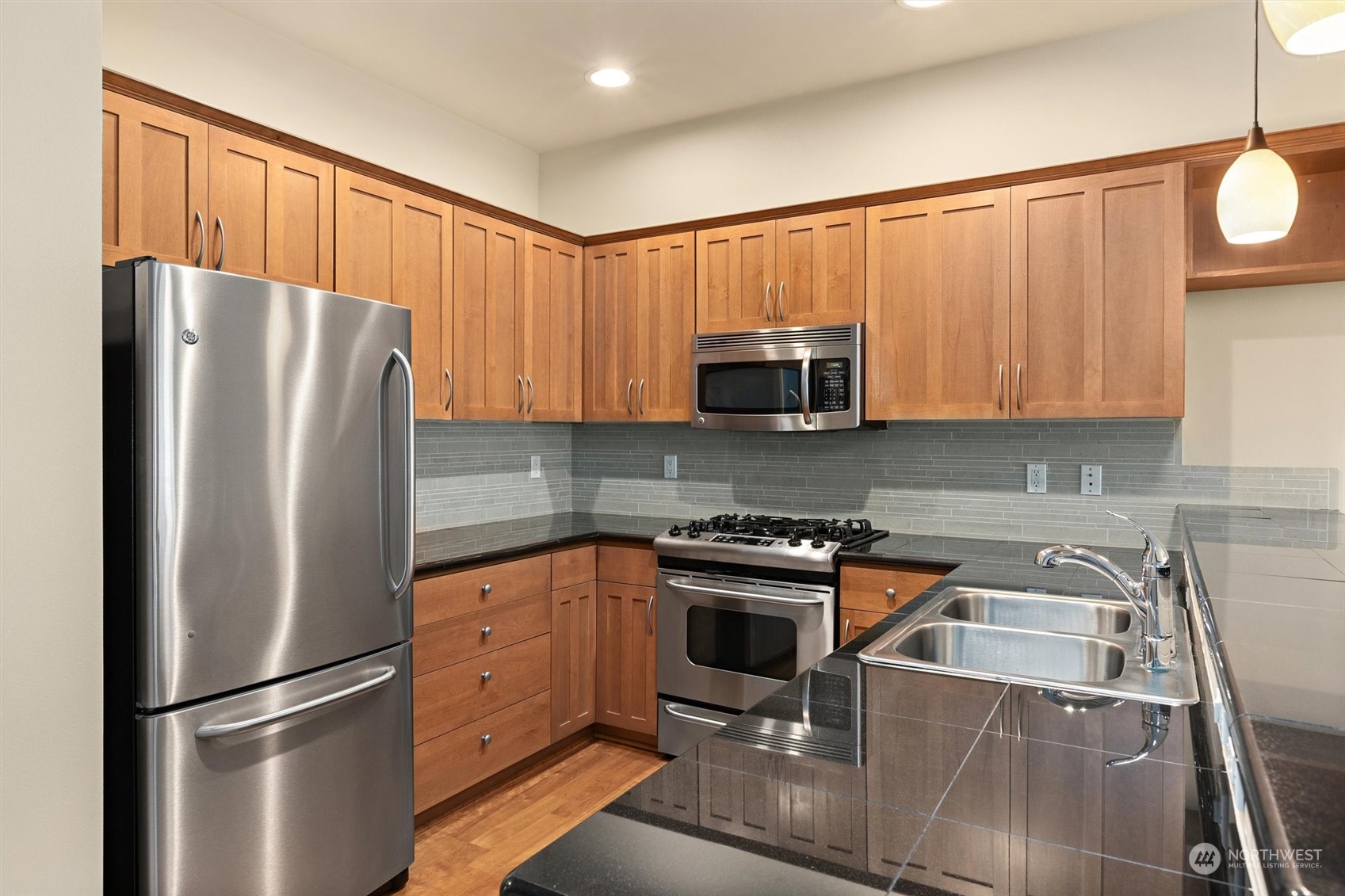 2115 201st Place Southeast, Unit I4 Bothell, WA 98012 - Photo 4 of 24 a kitchen with stainless steel appliances granite countertop a refrigerator stove and microwave