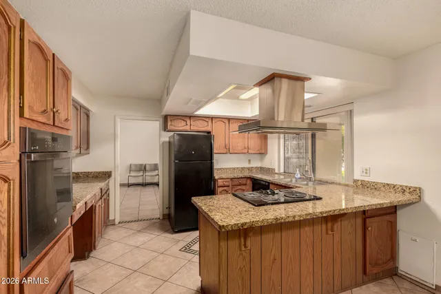 a kitchen with stainless steel appliances granite countertop a refrigerator a stove and a sink