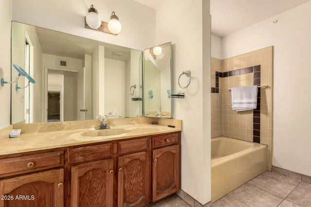 a bathroom with a tub sink and mirror