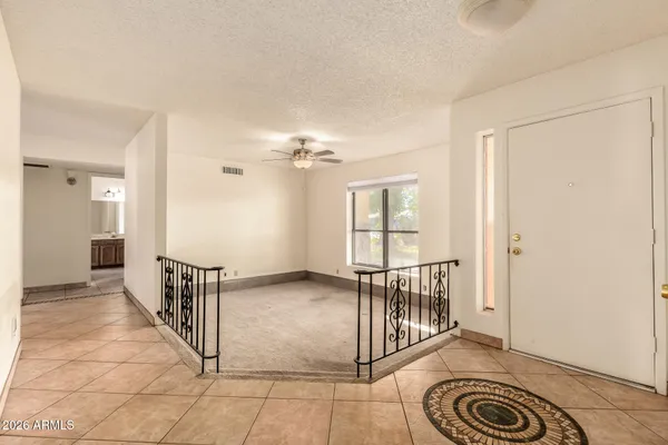 a view of a hallway with wooden floor and a chandelier