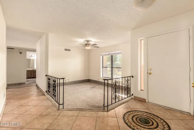 a view of a hallway with wooden floor and a chandelier