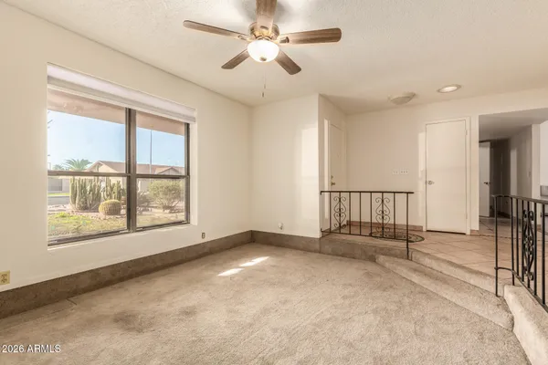 an empty room with windows and fan