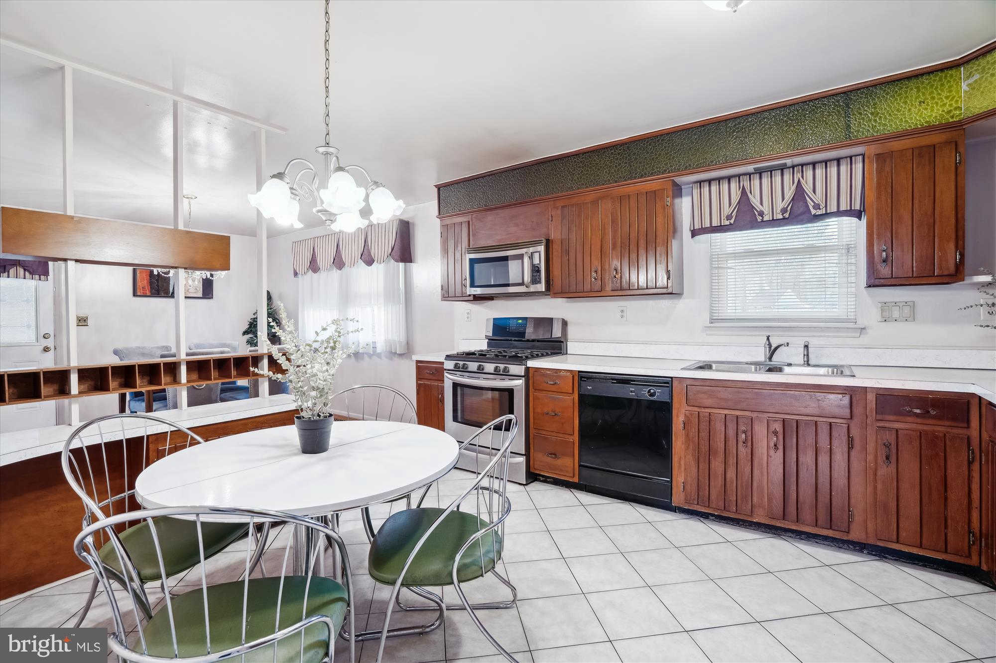 12103 Chesterton Drive Upper Marlboro, MD 20774 - Photo 11 of 30 a kitchen with granite countertop a stove a sink a microwave and dining table