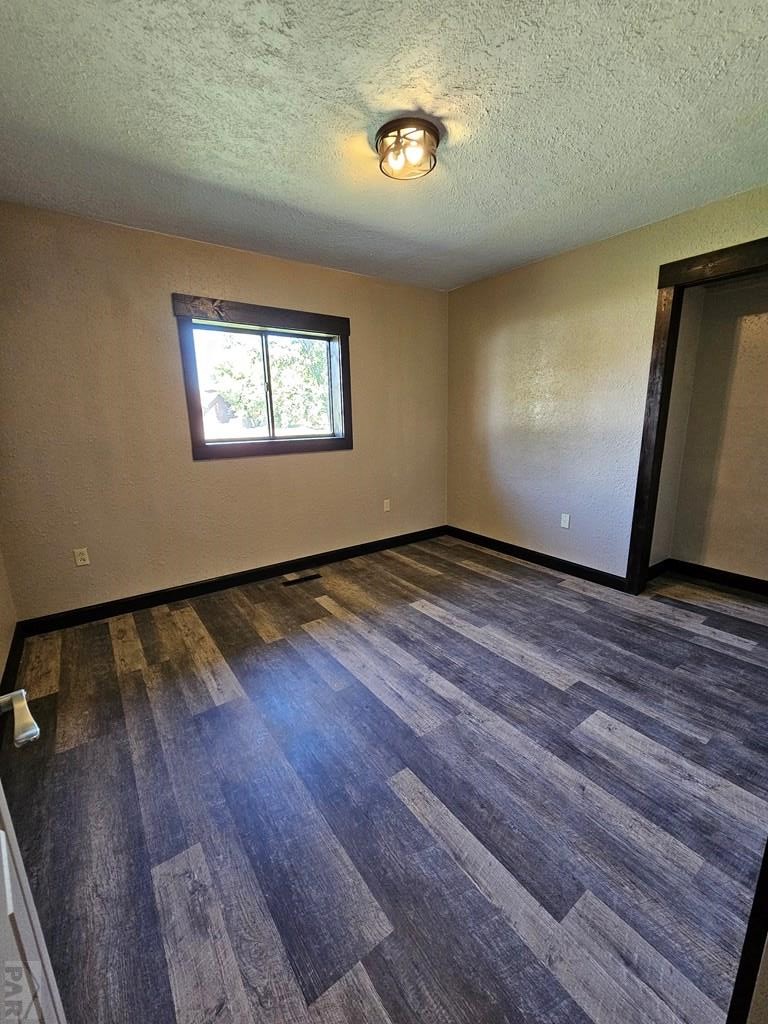 401 Park Street Springfield, CO 81073 - Photo 13 of 50 an empty room with wooden floor and windows