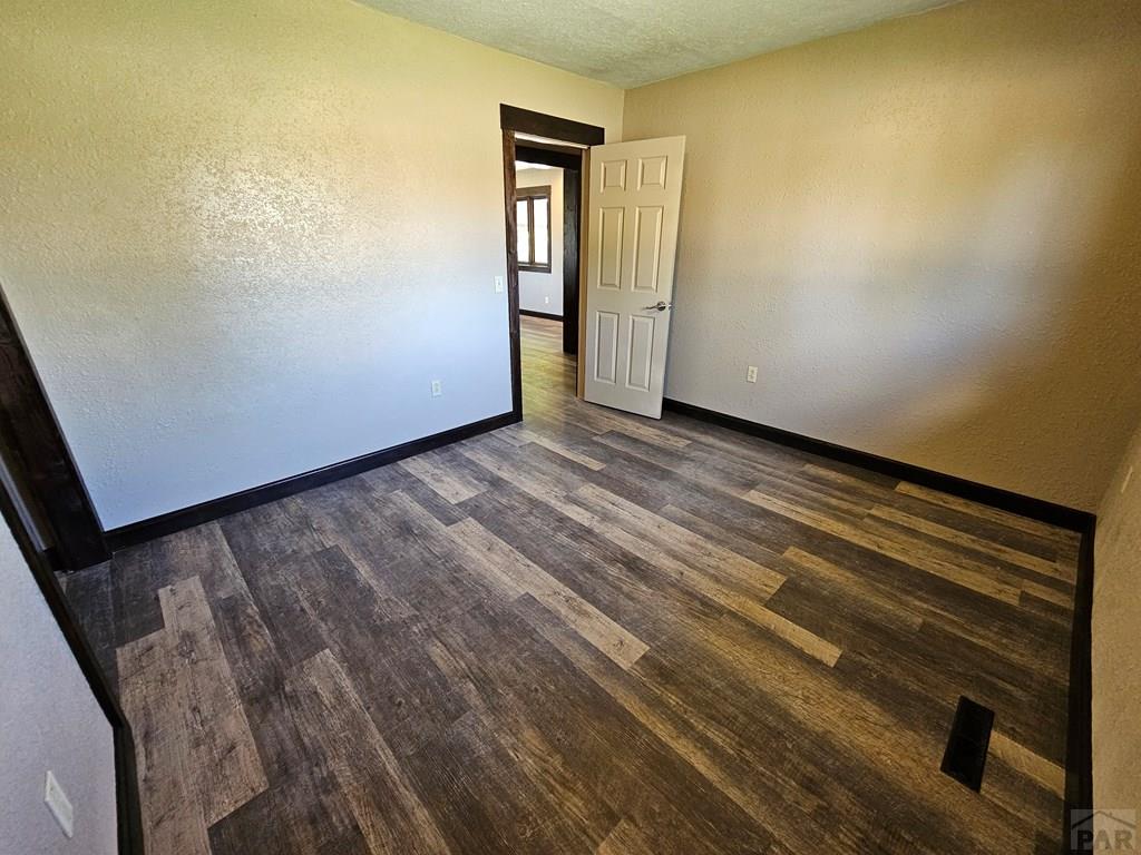 401 Park Street Springfield, CO 81073 - Photo 14 of 50 a view of empty room with wooden floor