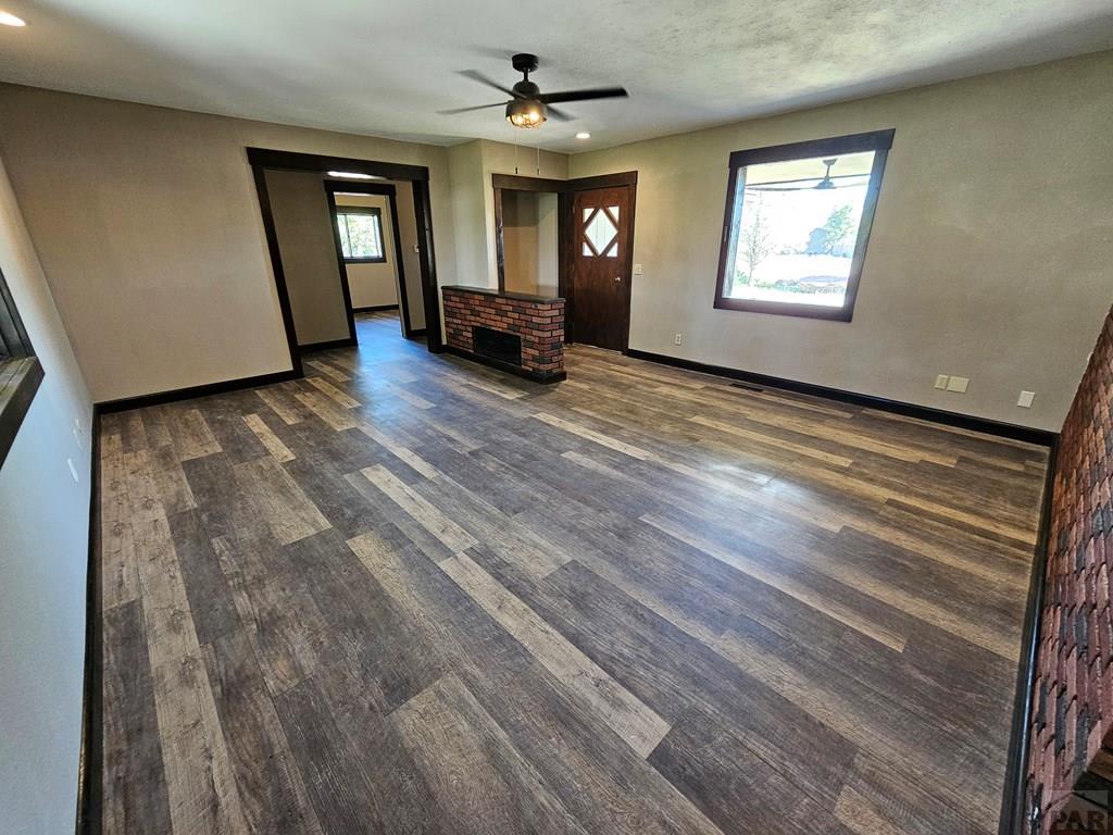 401 Park Street Springfield, CO 81073 - Photo 5 of 50 a view of a livingroom with wooden floor and a ceiling fan
