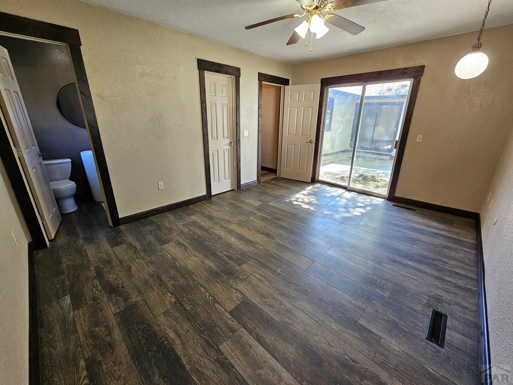 401 Park Street Springfield, CO 81073 - Photo 10 of 50 an empty room with wooden floor and a ceiling fan