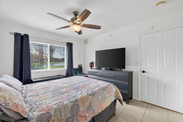 a bedroom with a bed and ceiling fan