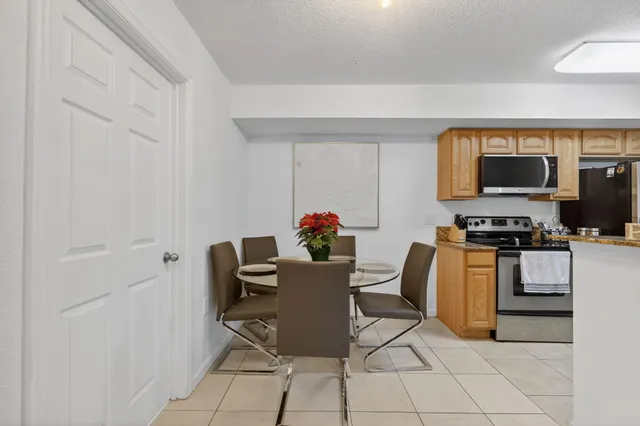 a dining room with furniture and kitchen view
