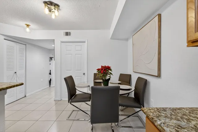 a view of a dining room with furniture and a potted plant