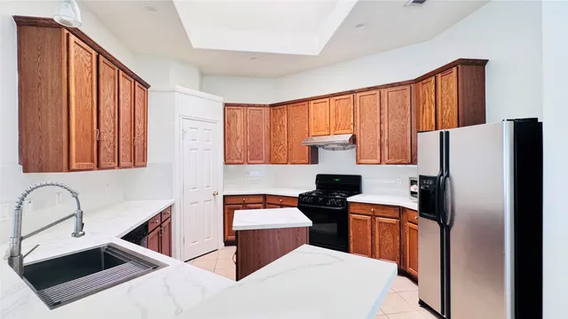 a kitchen with stainless steel appliances a refrigerator sink and cabinets