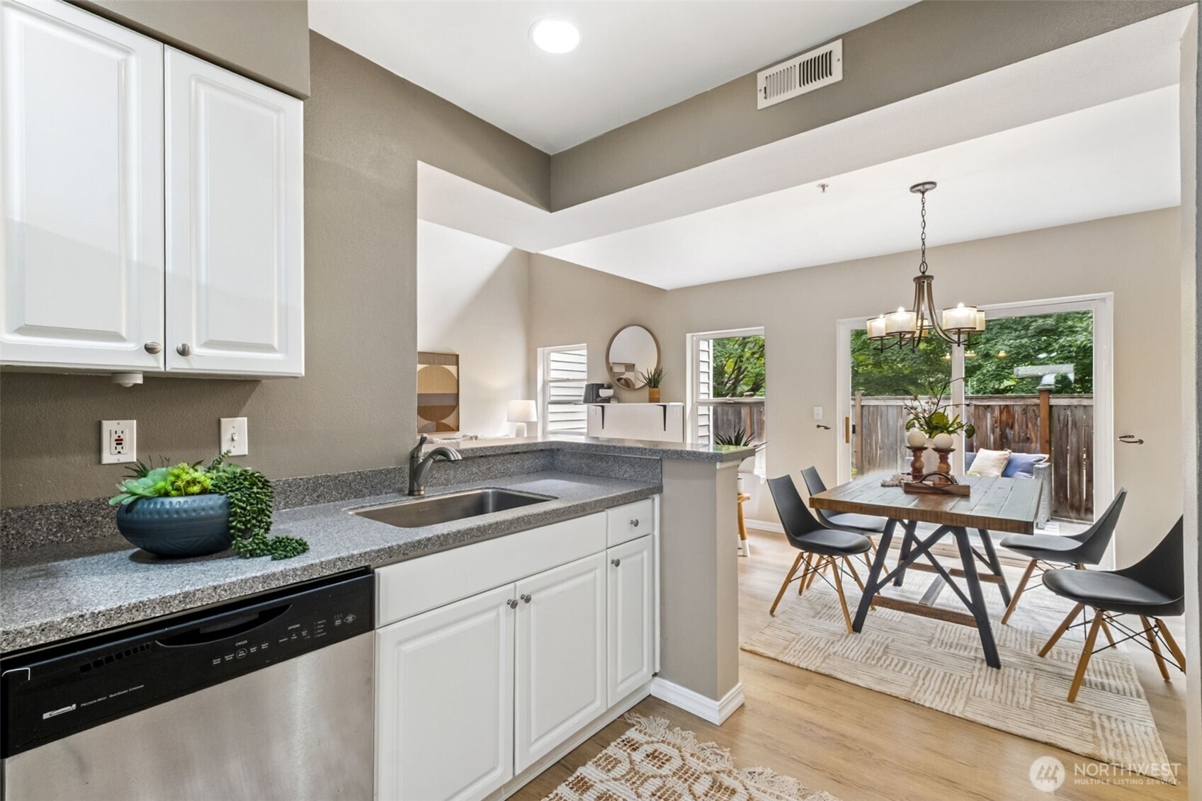 4808 Northeast Sunset Boulevard, Unit A102 Renton, WA 98059 - Photo 11 of 30 a kitchen with granite countertop white cabinets and chairs