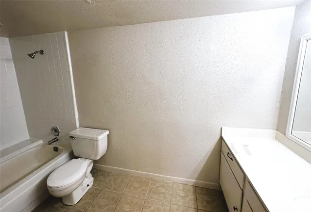 a white toilet sitting next to a white sink and vanity