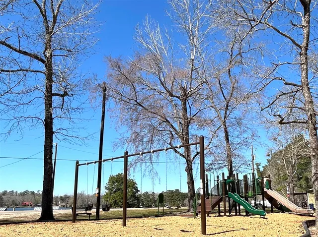 a view of a green field with trees in the background