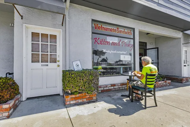a dining room with stainless steel appliances kitchen island granite countertop a table chairs and a refrigerator