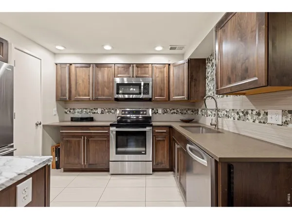 a kitchen with stainless steel appliances granite countertop a stove a sink and a microwave