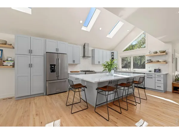 a kitchen with stainless steel appliances kitchen island hardwood floor stove sink and cabinets