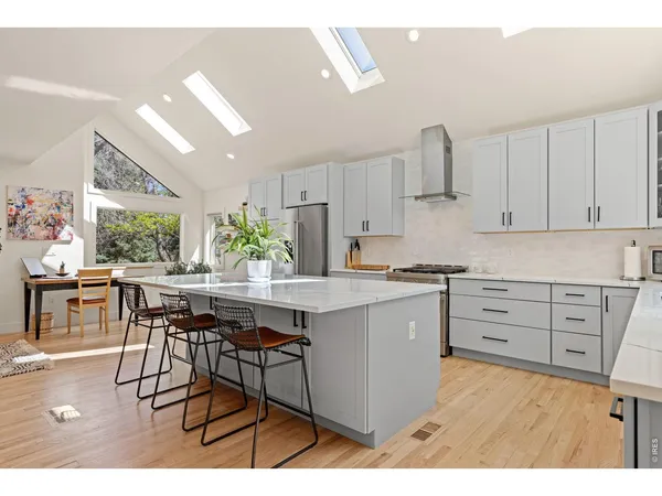 a kitchen with kitchen island granite countertop a table chairs sink and cabinets