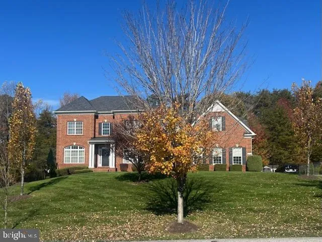 a view of a big yard in front of a house with a large tree