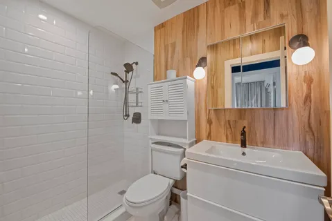a bathroom with a toilet a sink and mirror