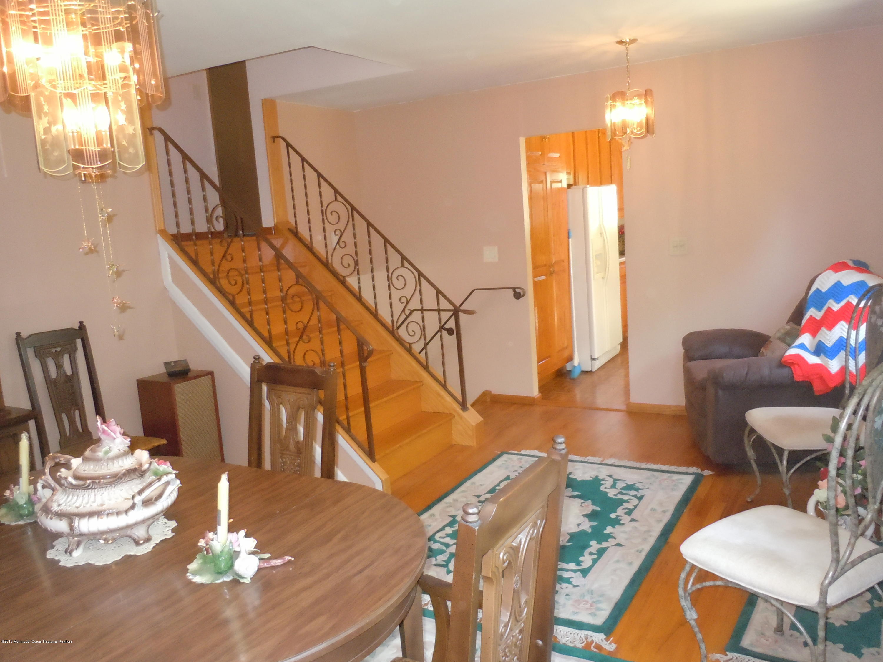 7 Peach Tree Road Oakhurst, NJ 07755 - Photo 14 of 36 a dining room with wooden floor a glass table and chairs