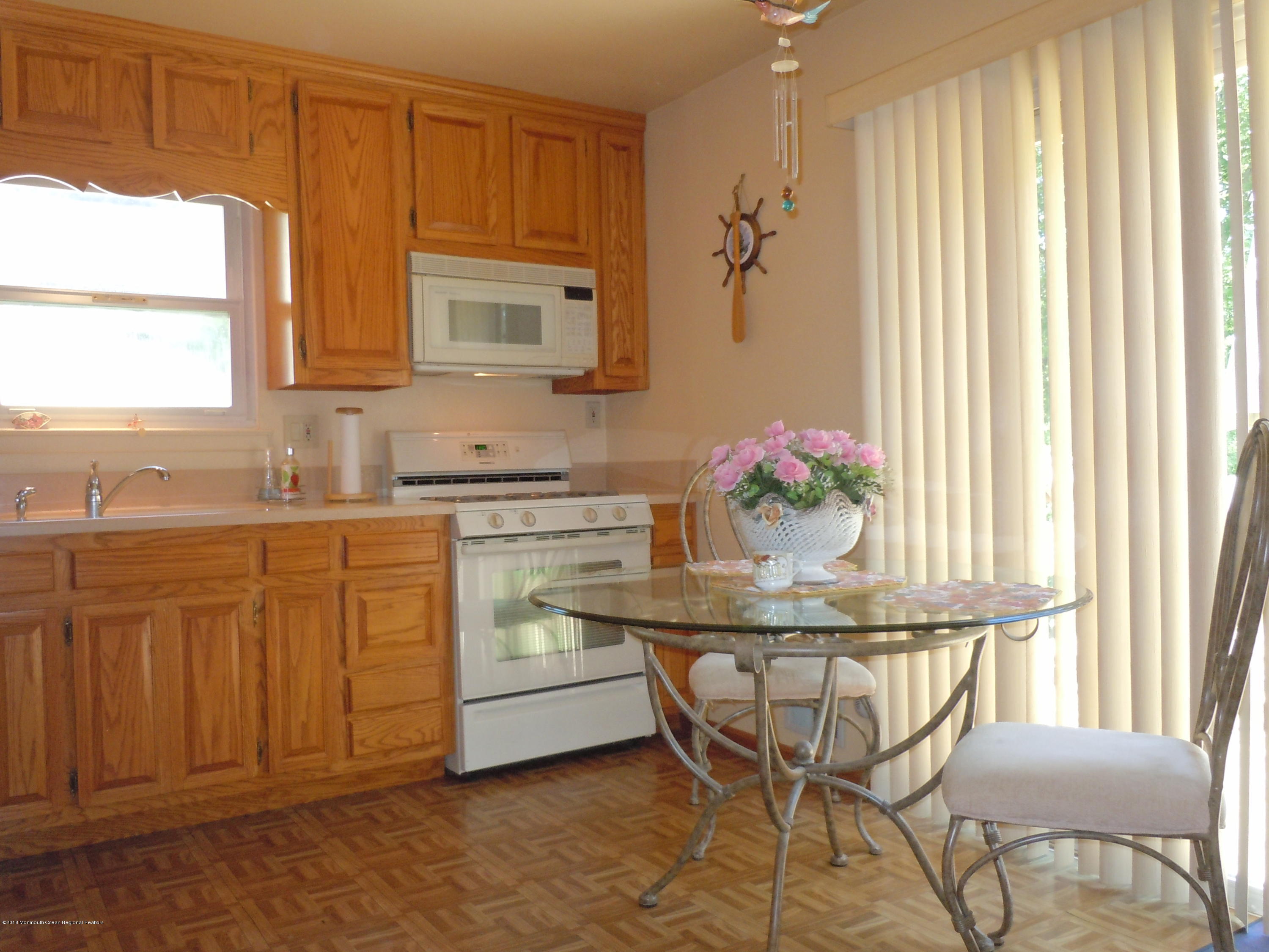 7 Peach Tree Road Oakhurst, NJ 07755 - Photo 22 of 36 a kitchen with a stove cabinets dining table and chairs