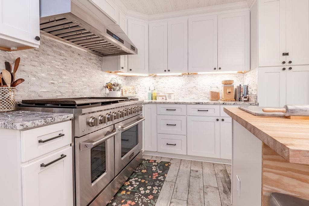 5870 Monk House Road Somerville, TN 38068 - Photo 15 of 40 a kitchen with stainless steel appliances granite countertop a stove and white cabinets