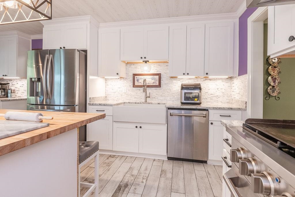 5870 Monk House Road Somerville, TN 38068 - Photo 16 of 40 a kitchen with stainless steel appliances white cabinets and a stove top oven