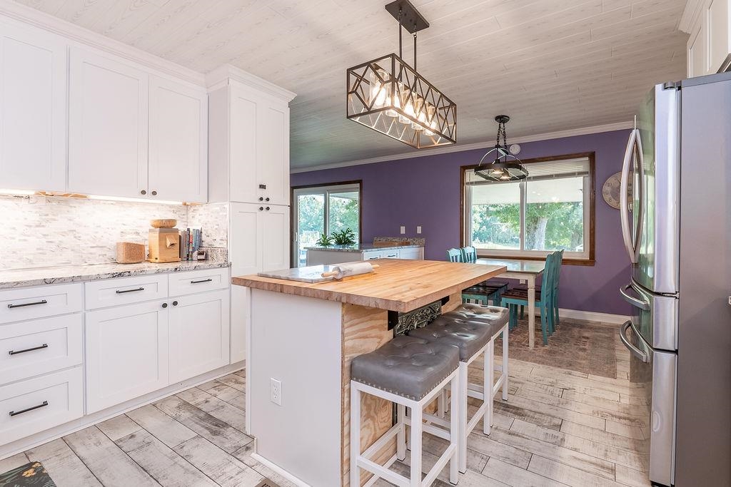 5870 Monk House Road Somerville, TN 38068 - Photo 17 of 40 a kitchen with stainless steel appliances granite countertop a stove a refrigerator a sink and white cabinets with wooden floor