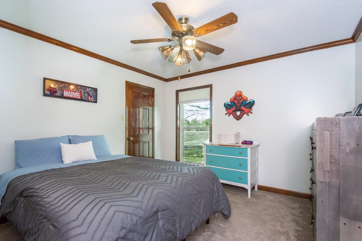 5870 Monk House Road Somerville, TN 38068 - Photo 24 of 40 a bedroom with a bed and a chandelier