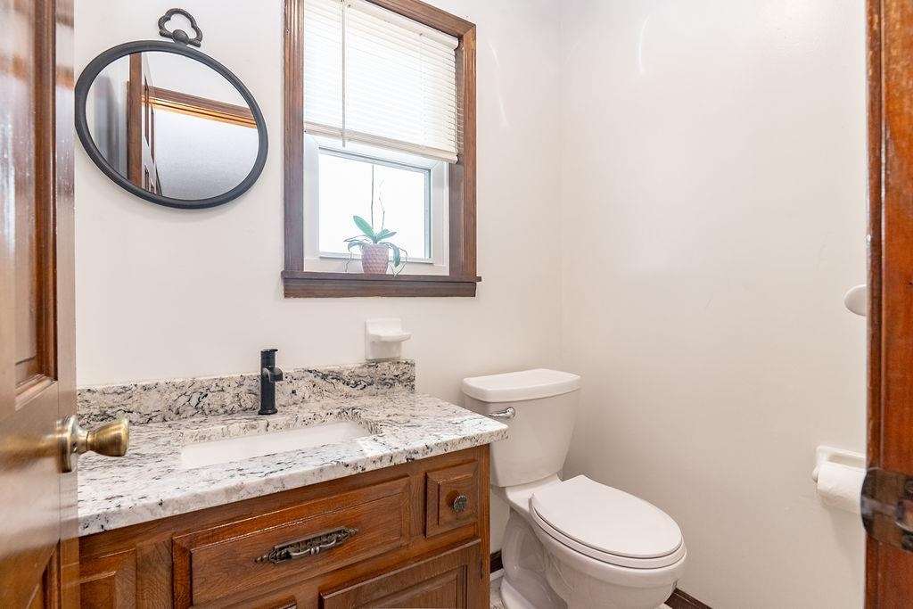 5870 Monk House Road Somerville, TN 38068 - Photo 31 of 40 a bathroom with a granite countertop toilet a sink and a mirror