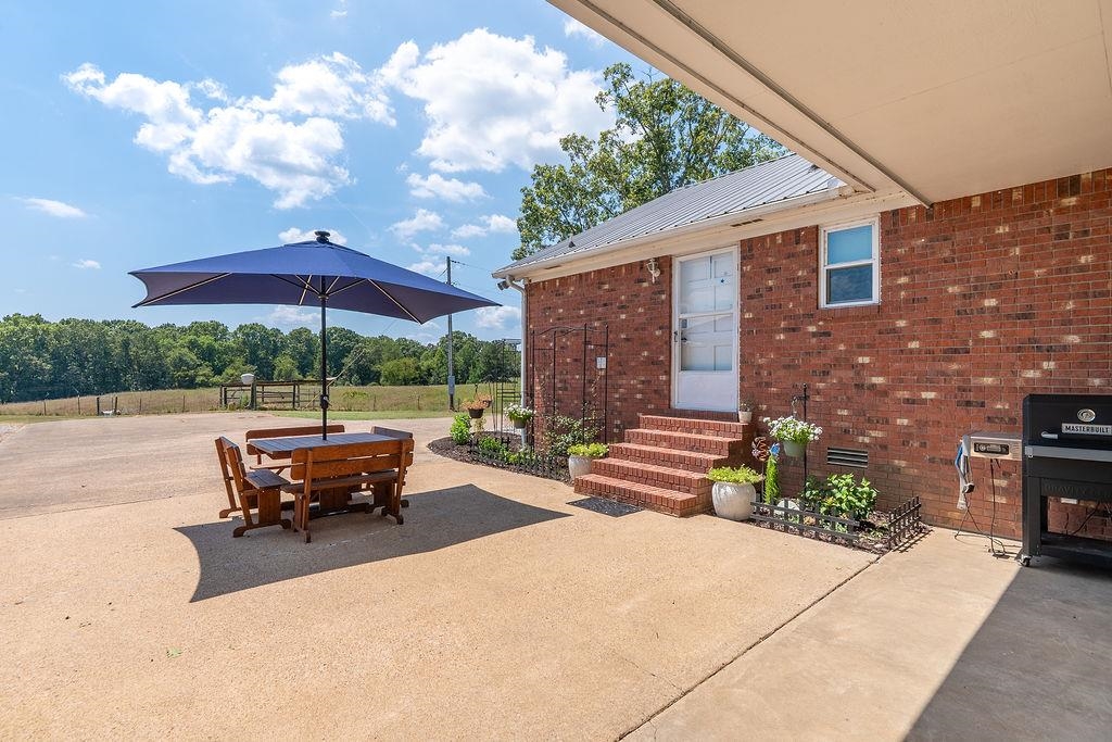 5870 Monk House Road Somerville, TN 38068 - Photo 4 of 40 a view of a patio with a table and chairs under an umbrella
