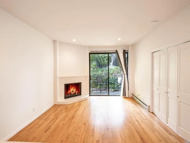 an empty room with wooden floor and a fireplace