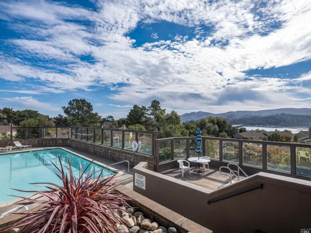 a view of a roof deck with couches and sky view