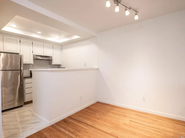 a view of a kitchen with a sink and a refrigerator