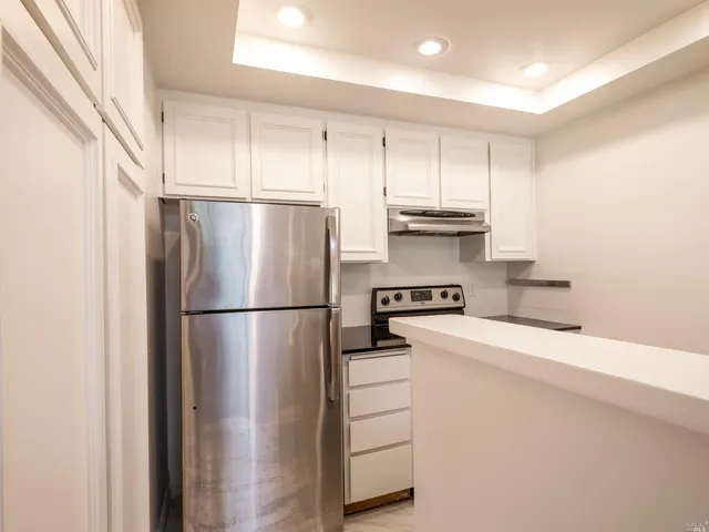 a white refrigerator freezer and a stove sitting inside of a kitchen