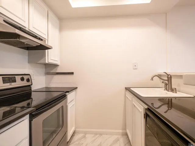 a kitchen with a sink cabinets and stainless steel appliances