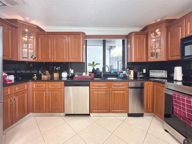 a kitchen with stainless steel appliances granite countertop a refrigerator sink and cabinets