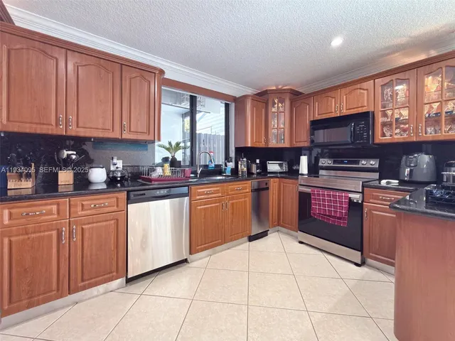 a kitchen with stainless steel appliances granite countertop a stove sink and cabinets