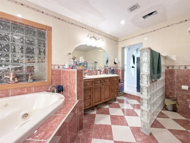 a large bathroom with a tub a sink a mirror and shower