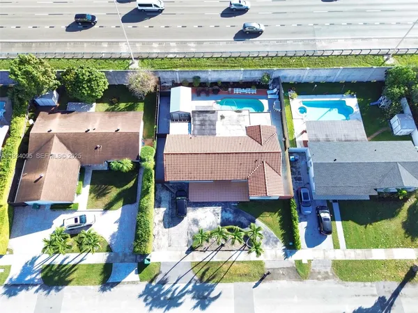an aerial view of a house with a yard and potted plants