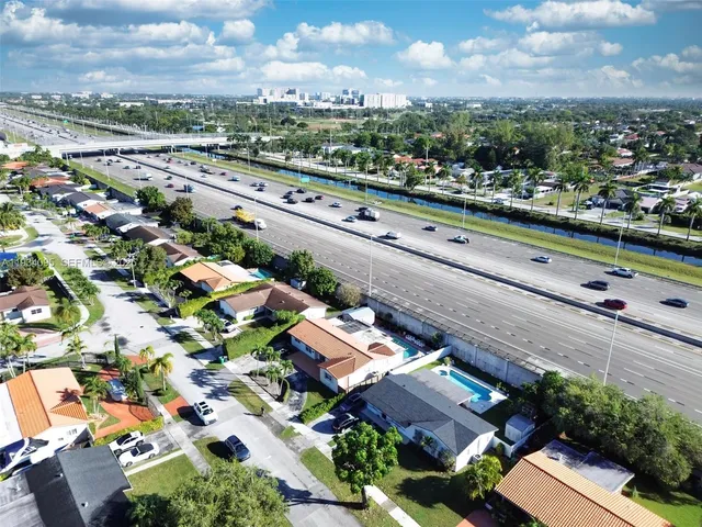 an aerial view of a city with lots of residential buildings ocean and mountain view in back