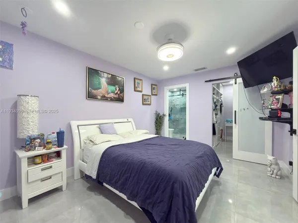a spacious bedroom with a bed and a cabinets
