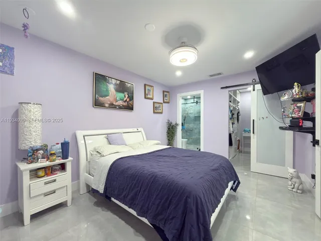 a spacious bedroom with a bed and a cabinets