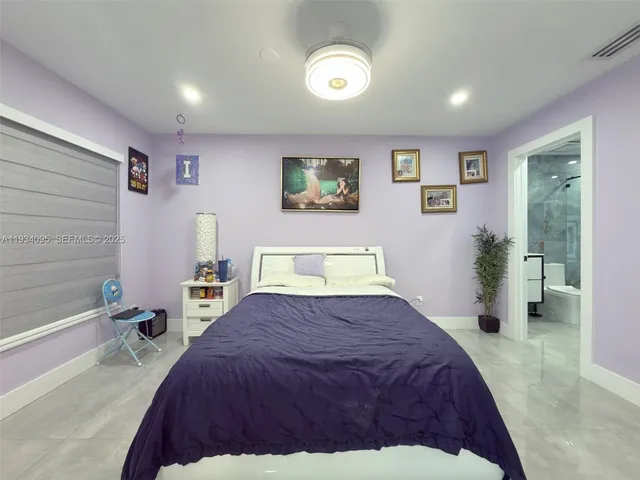 a spacious bedroom with a bed and a view of bathroom